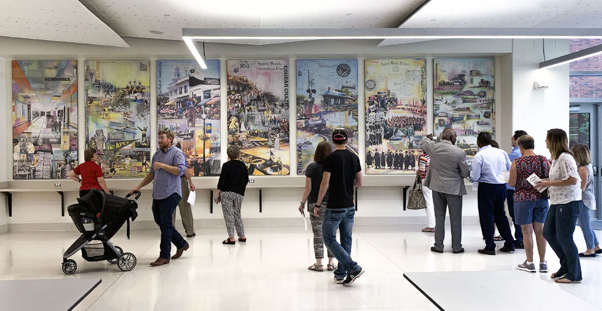 Visitors viewing murals in the cafeteria of Apex High School during the open house event for the community